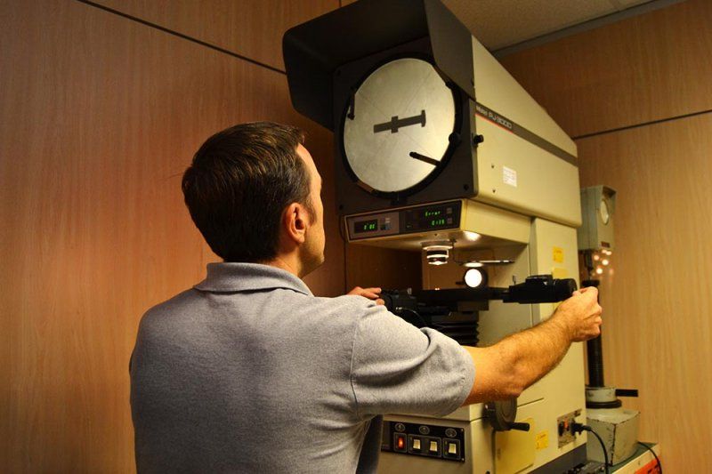 Un hombre está parado frente a una máquina con un reloj en ella.