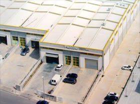 Una vista aérea de un almacén con coches aparcados delante.