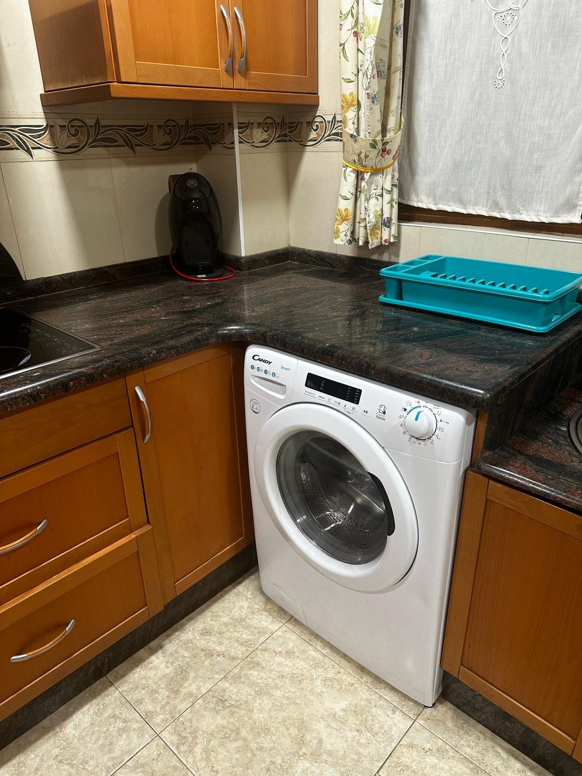 Una cocina con lavadora y tendedero