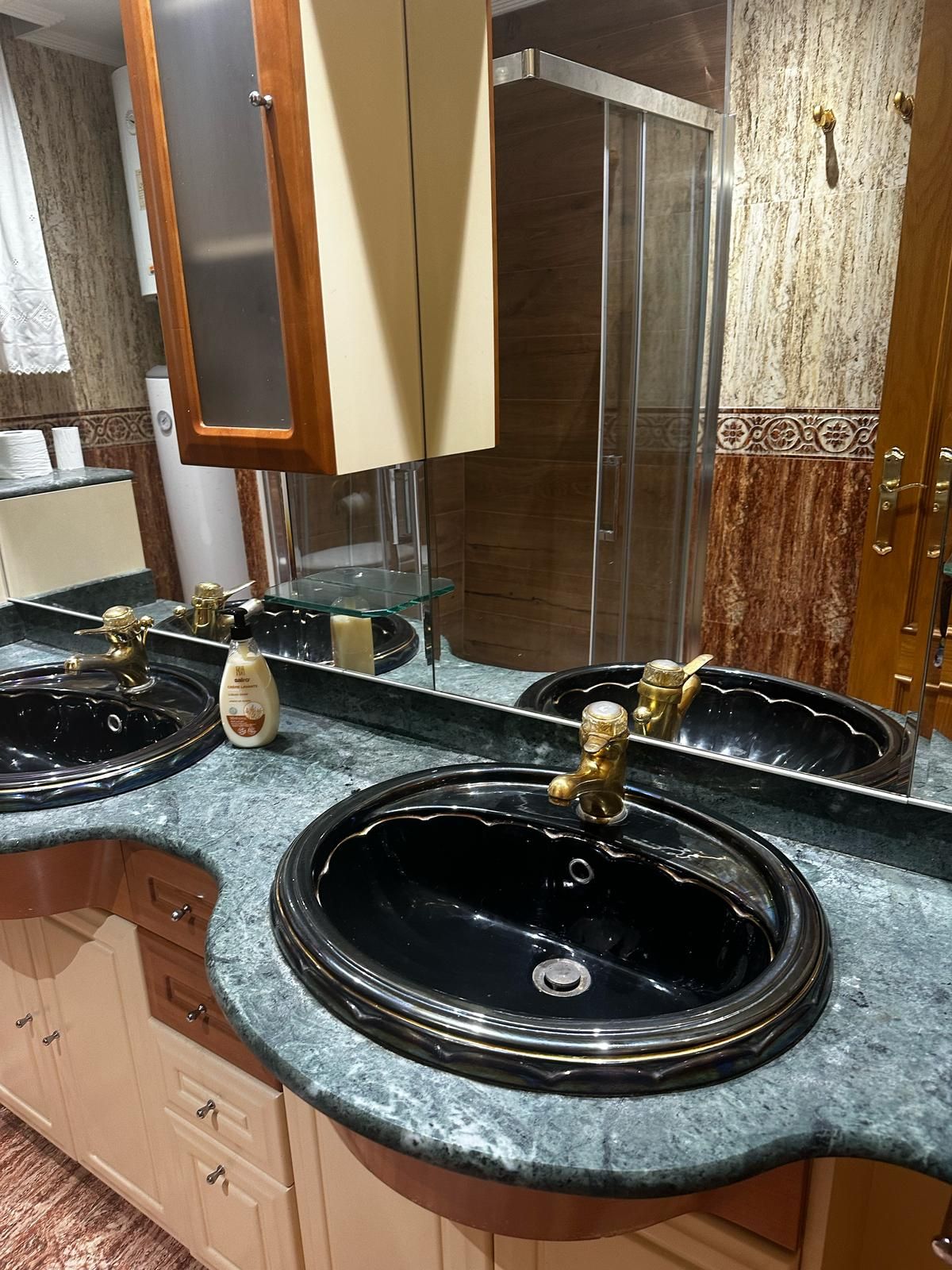 Un baño con dos lavabos y un espejo.