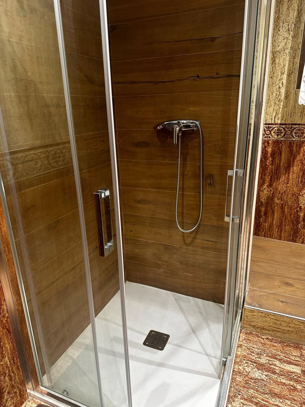 Una cabina de ducha con puerta corrediza de vidrio