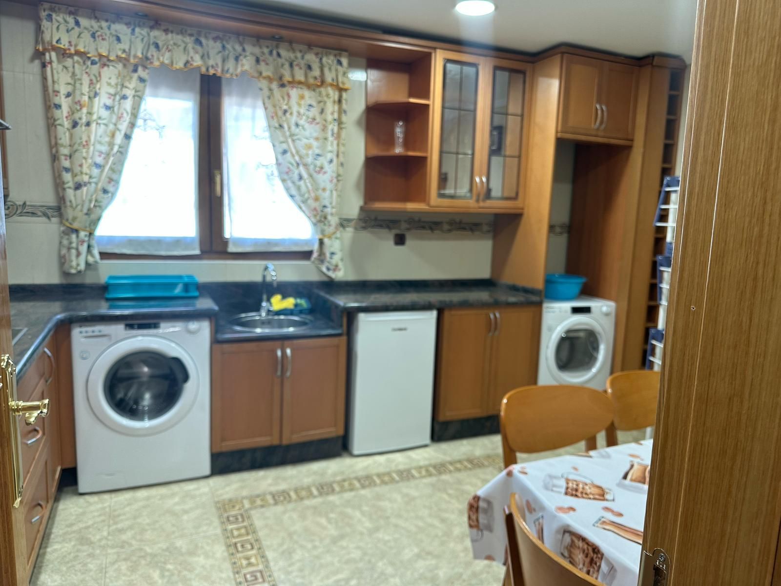 Una cocina con mesa y sillas y lavadora y secadora.