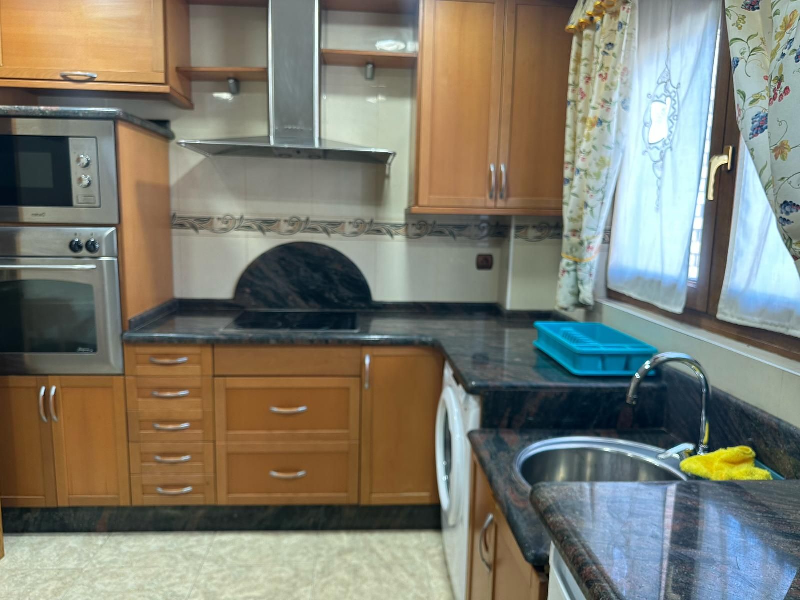 Una cocina con electrodomésticos de acero inoxidable y gabinetes de madera.