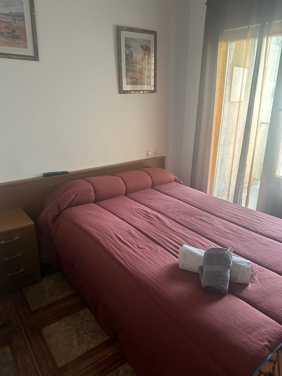 Un dormitorio con una cama y un cuadro en la pared.