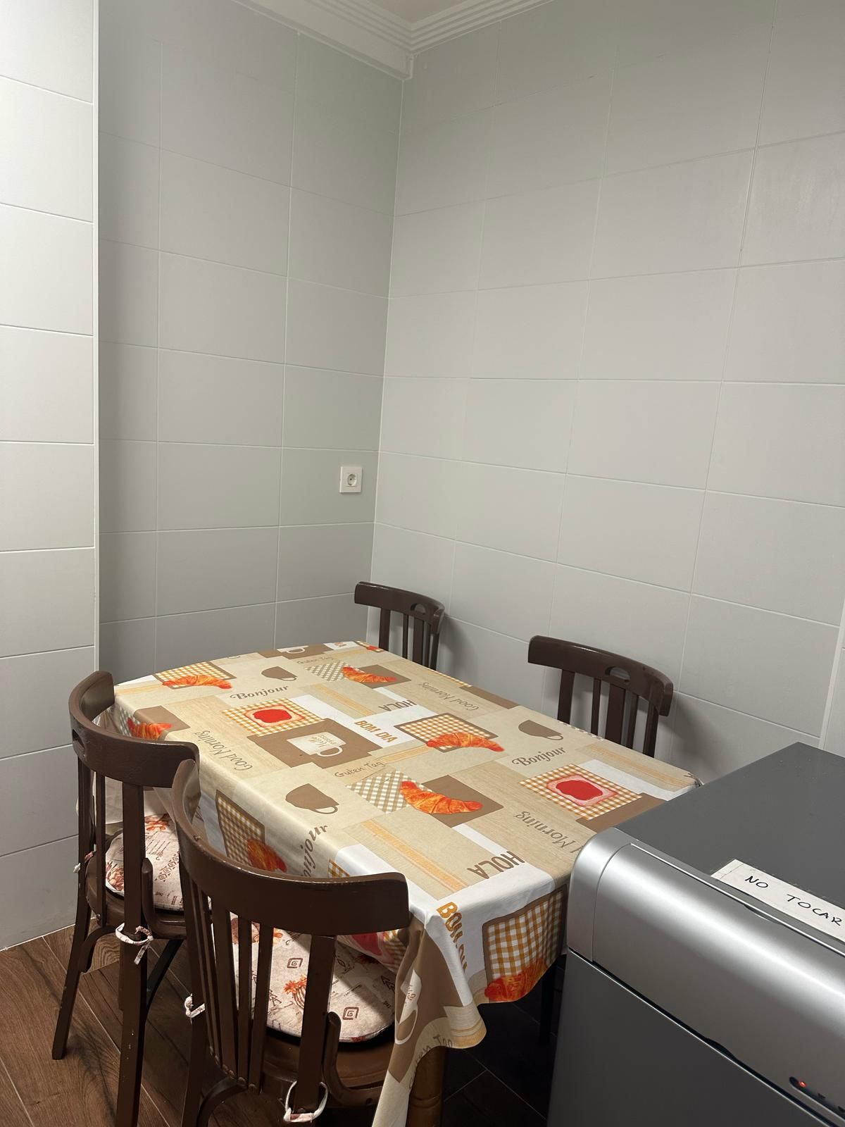 Una cocina con mesa y sillas y una nevera.