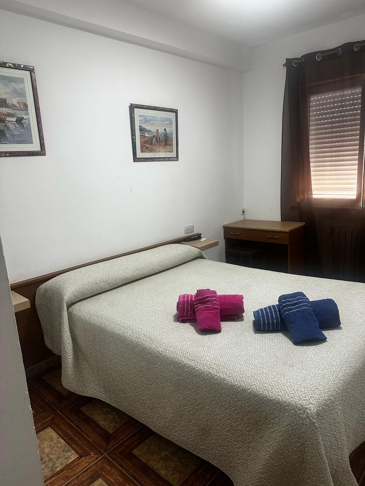 Un dormitorio con una cama y dos toallas encima.