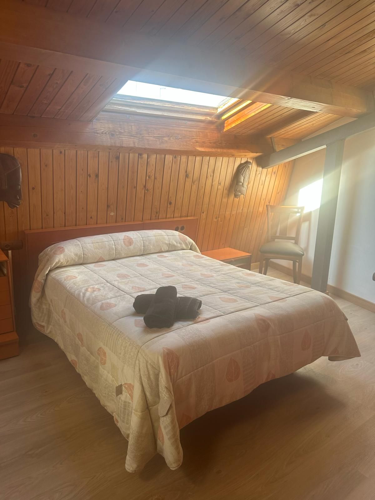 Un dormitorio con una cama y una claraboya en el techo.