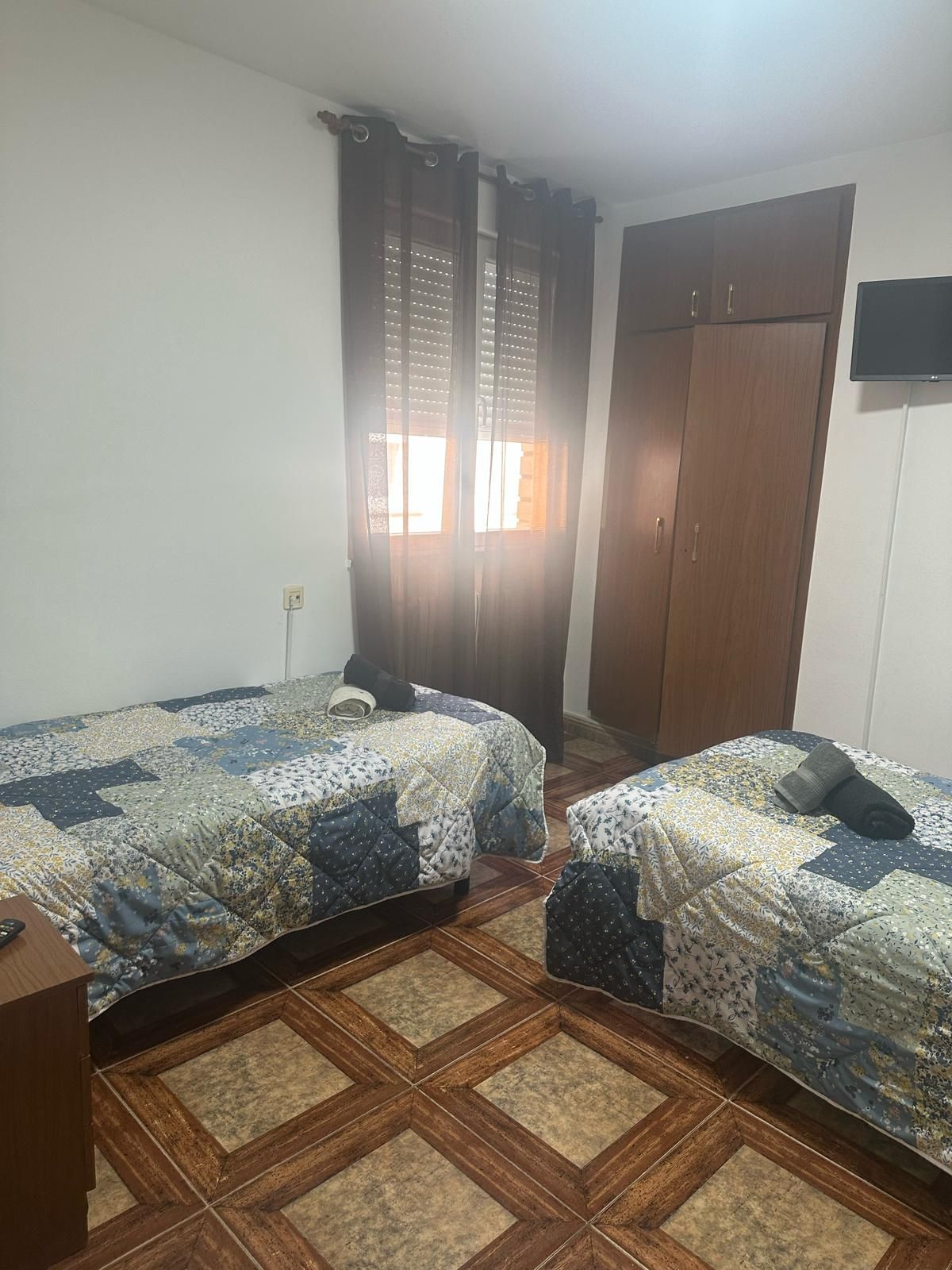 Un dormitorio con dos camas y una ventana.