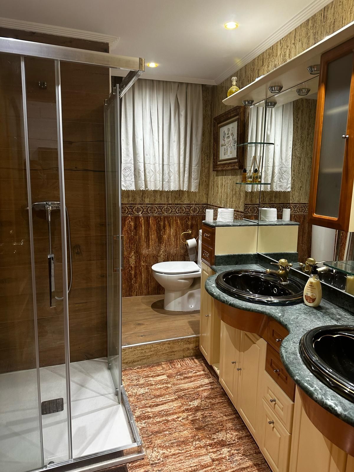 Un baño con dos lavabos, un inodoro y una ducha.