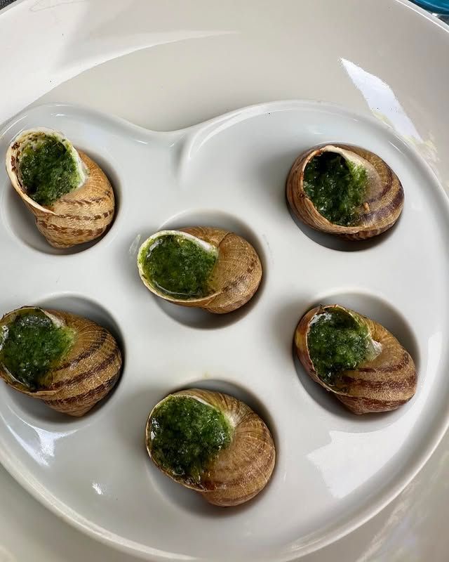 Assiette de six canapés aux champignons nappés d'une sauce aux herbes vertes, disposés en cercle.