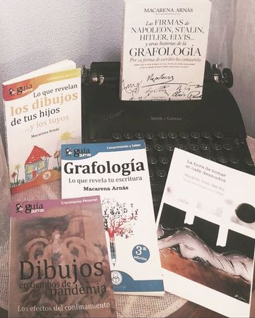 Un montón de libros sobre una mesa incluyendo dibujos.