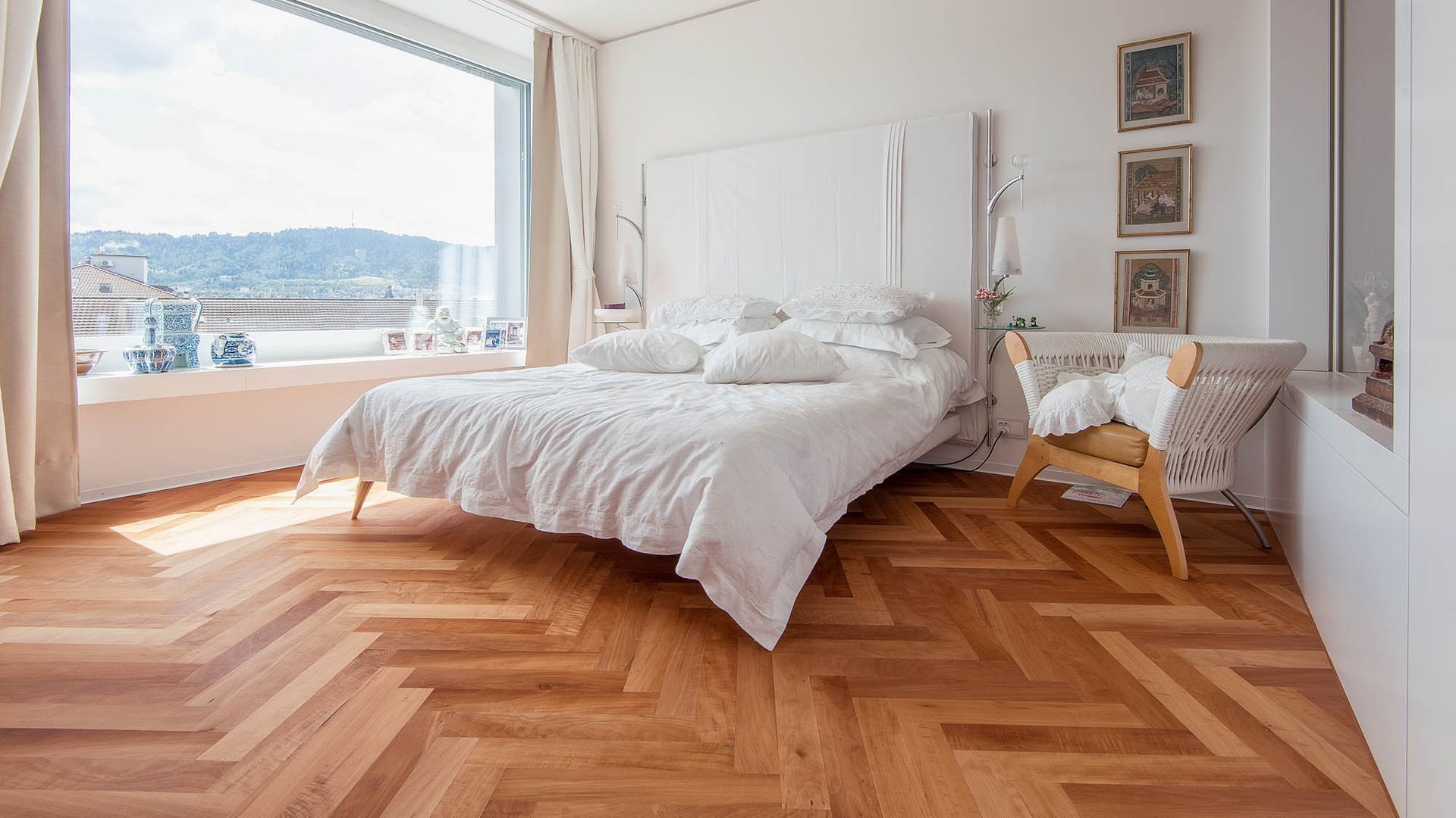 Ein Schlafzimmer mit Bett, Stuhl, Fenster und Holzboden.