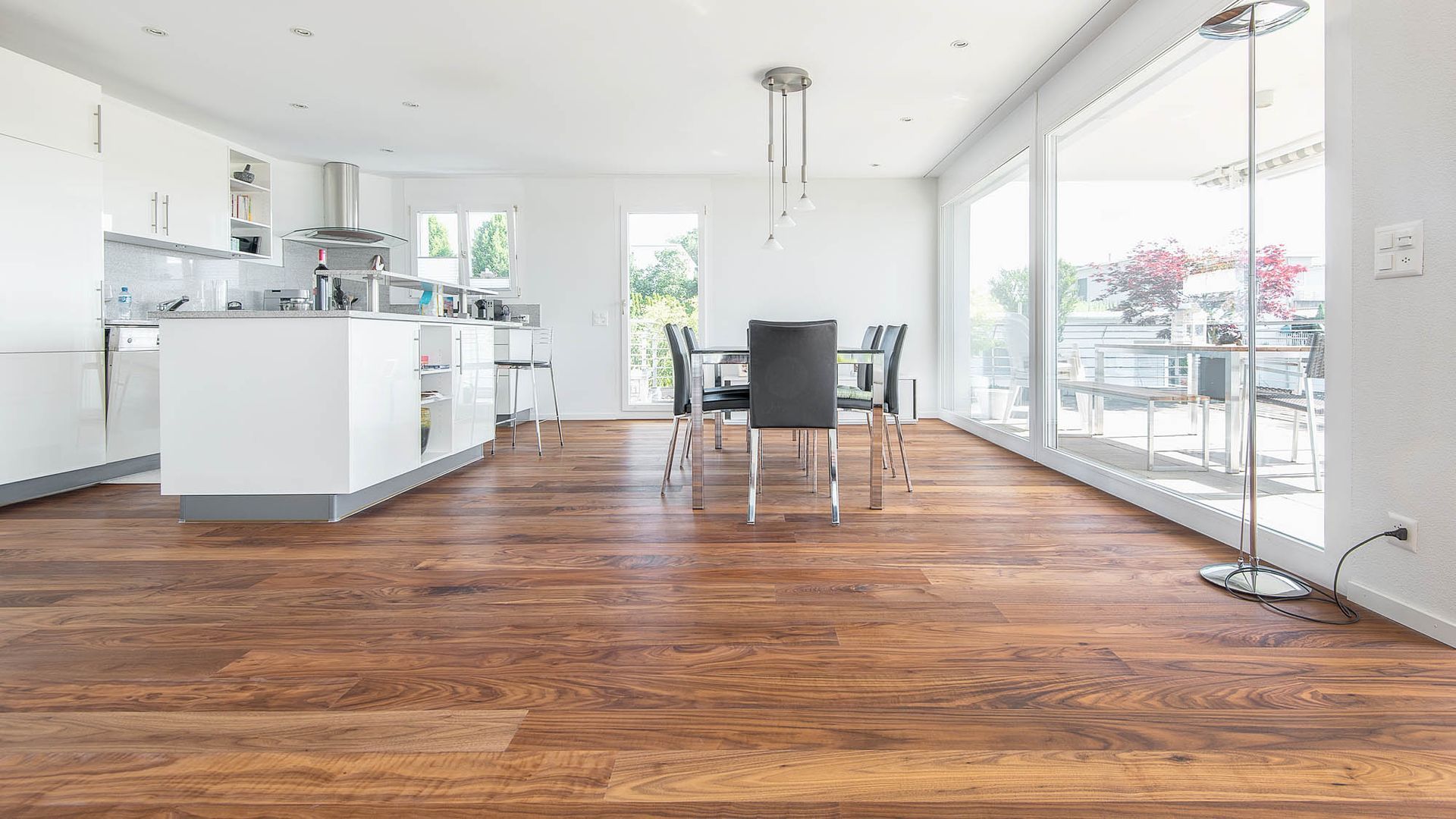 Eine Küche und ein Esszimmer mit Holzböden und vielen Fenstern.