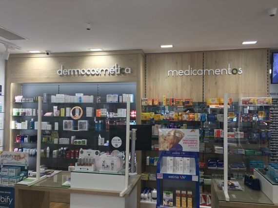 Una farmacia con un mostrador y estantes llenos de muchos productos.