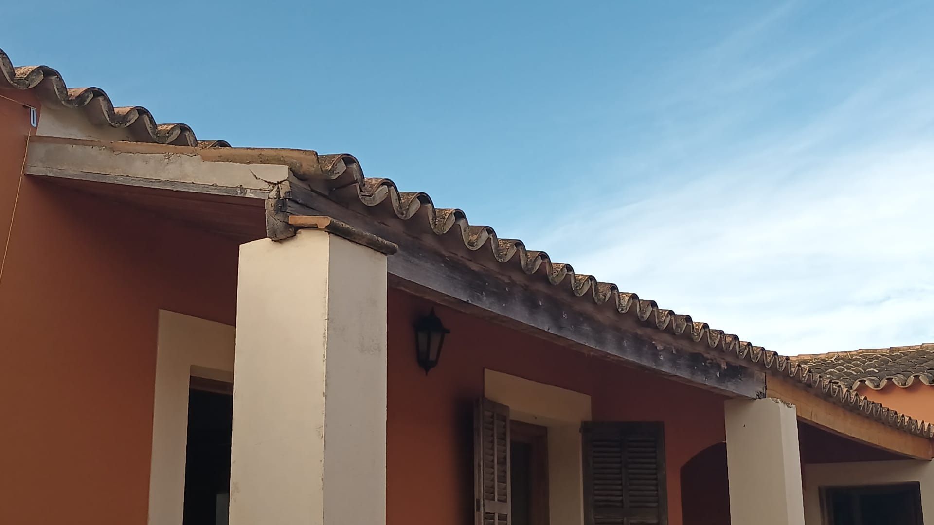 Un techo de un edificio con un cielo azul al fondo.