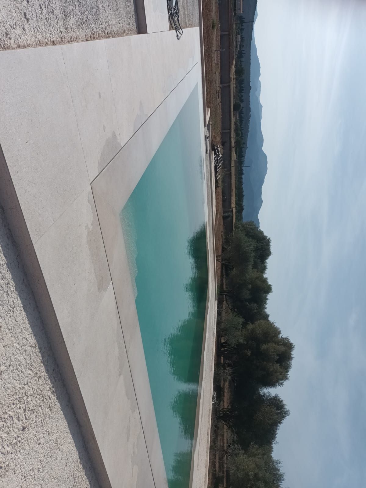 Una gran piscina con montañas al fondo.