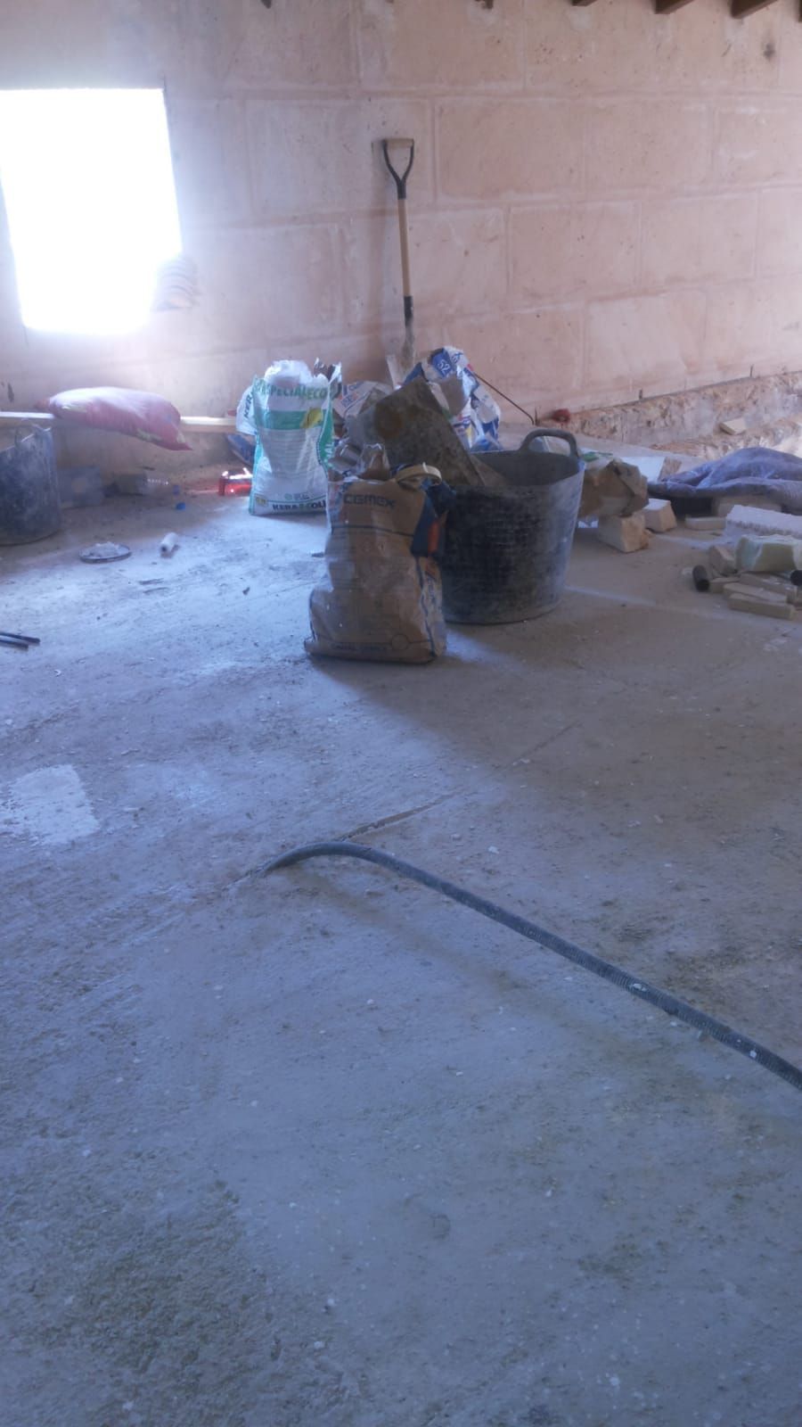 Una habitación con un montón de bolsas y cubos en el suelo.