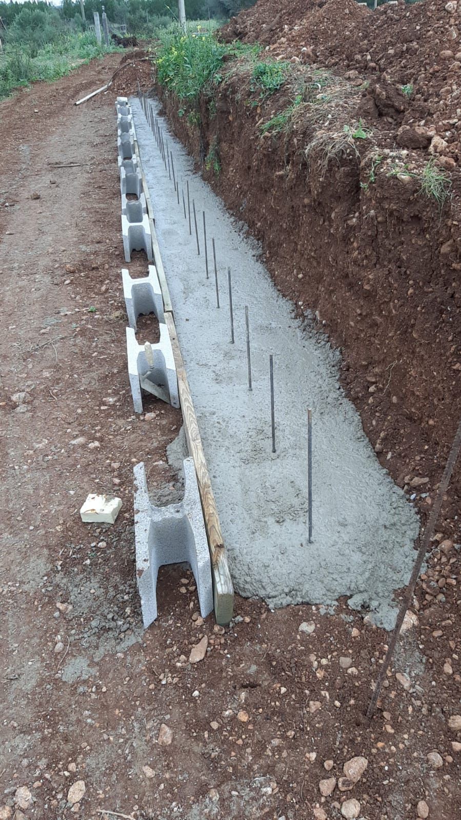 Se está construyendo un muro de hormigón en una zanja.