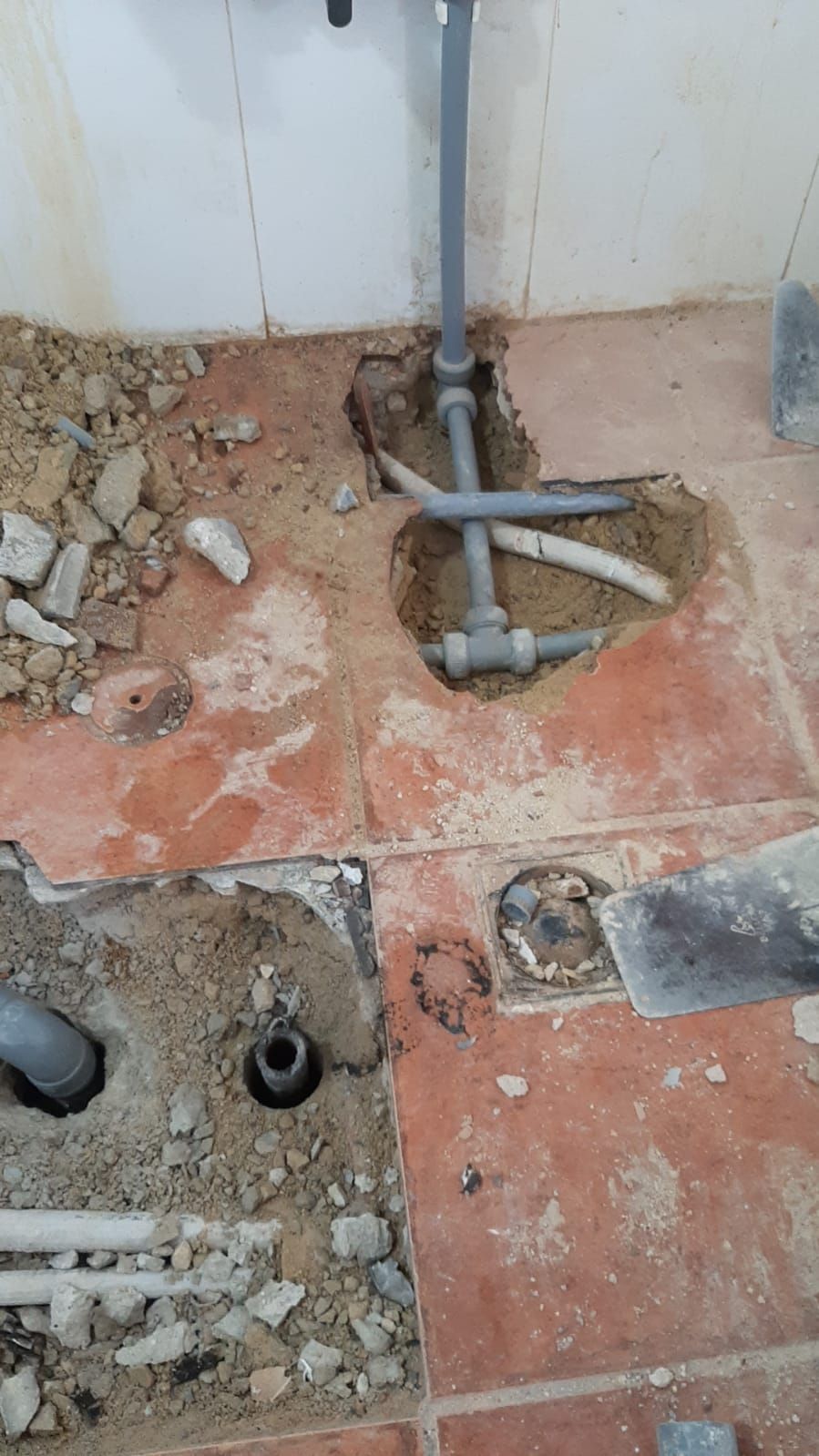 Un agujero en el suelo por donde salen tuberías.