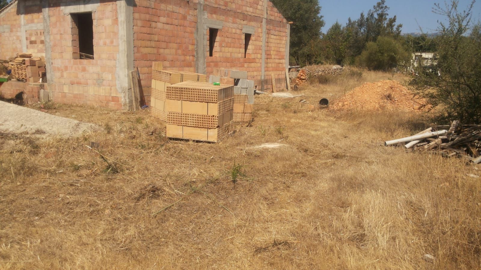 Se está construyendo un edificio de ladrillos en medio de un campo.