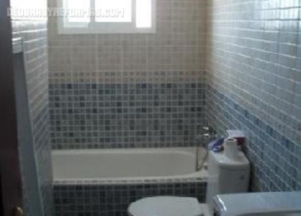 Un baño con inodoro, bañera y ventana.