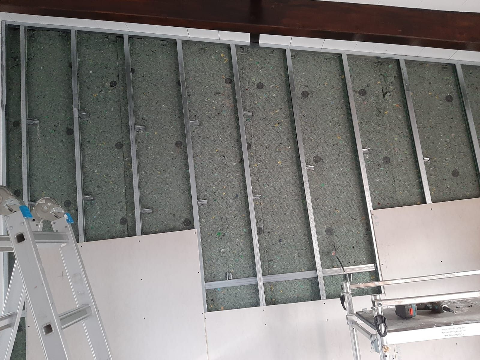 Una escalera está junto a un muro que se está construyendo.