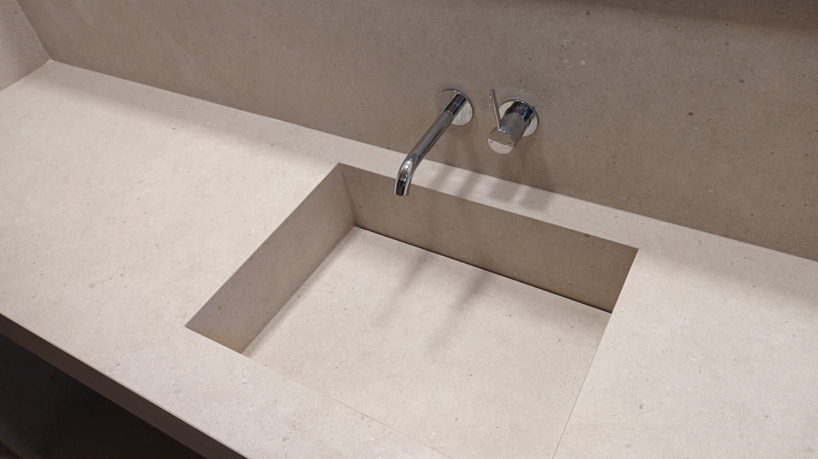 Un lavabo de baño con un grifo en la pared.