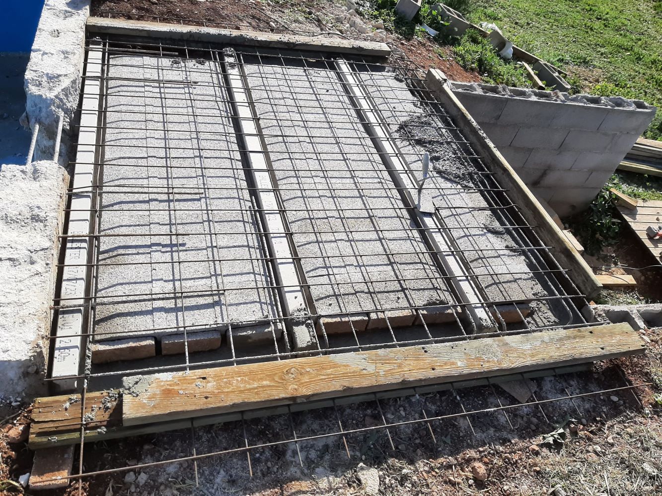 Se está construyendo una losa de hormigón al lado de una piscina.