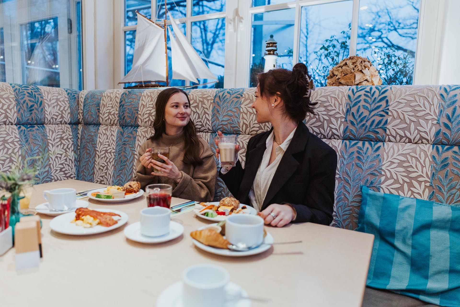 Zwei Frauen unterhalten sich bei einer Tasse Kaffee an einem Tisch.