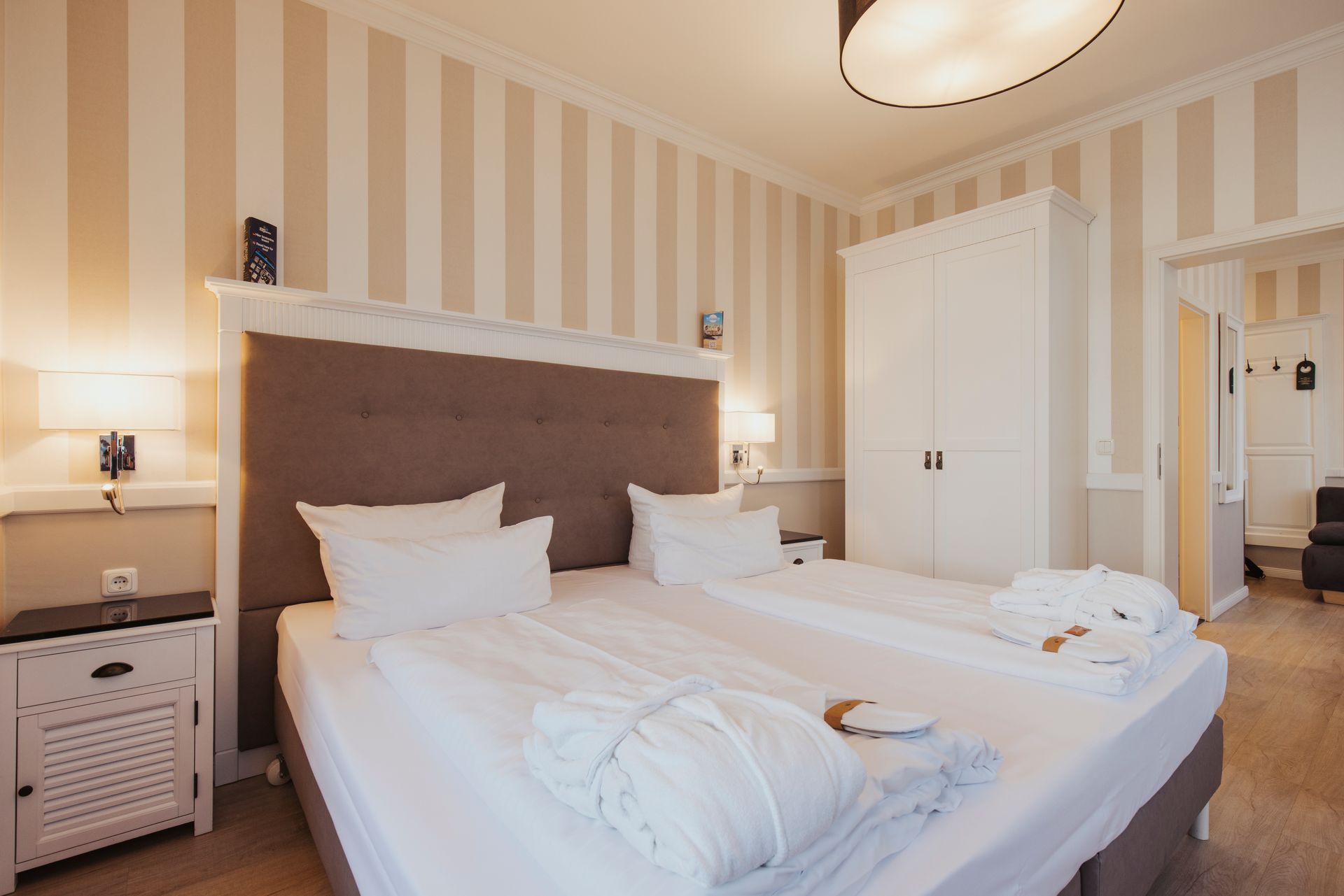 Ein Hotelzimmer mit einem großen Bett und gestreiften Wänden