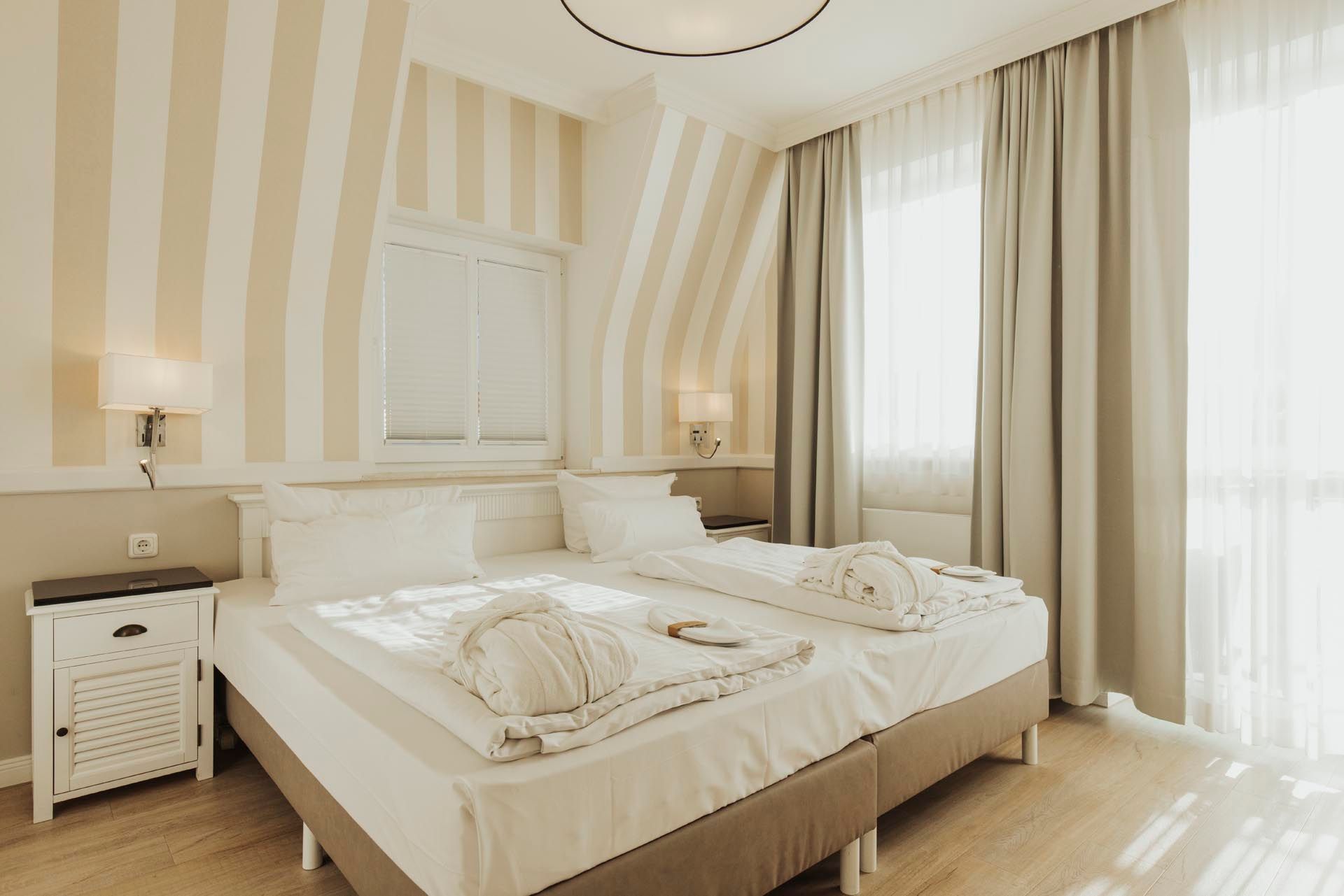 Ein Hotelzimmer mit zwei Betten und Balkon.