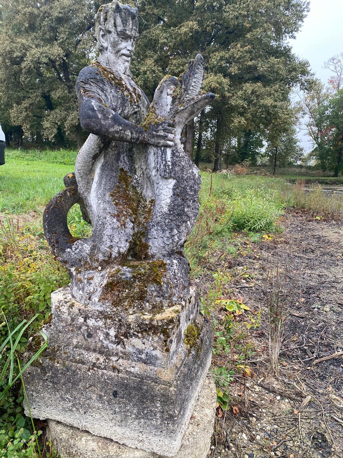 Statue en pierre dans un parc avant nettoyage