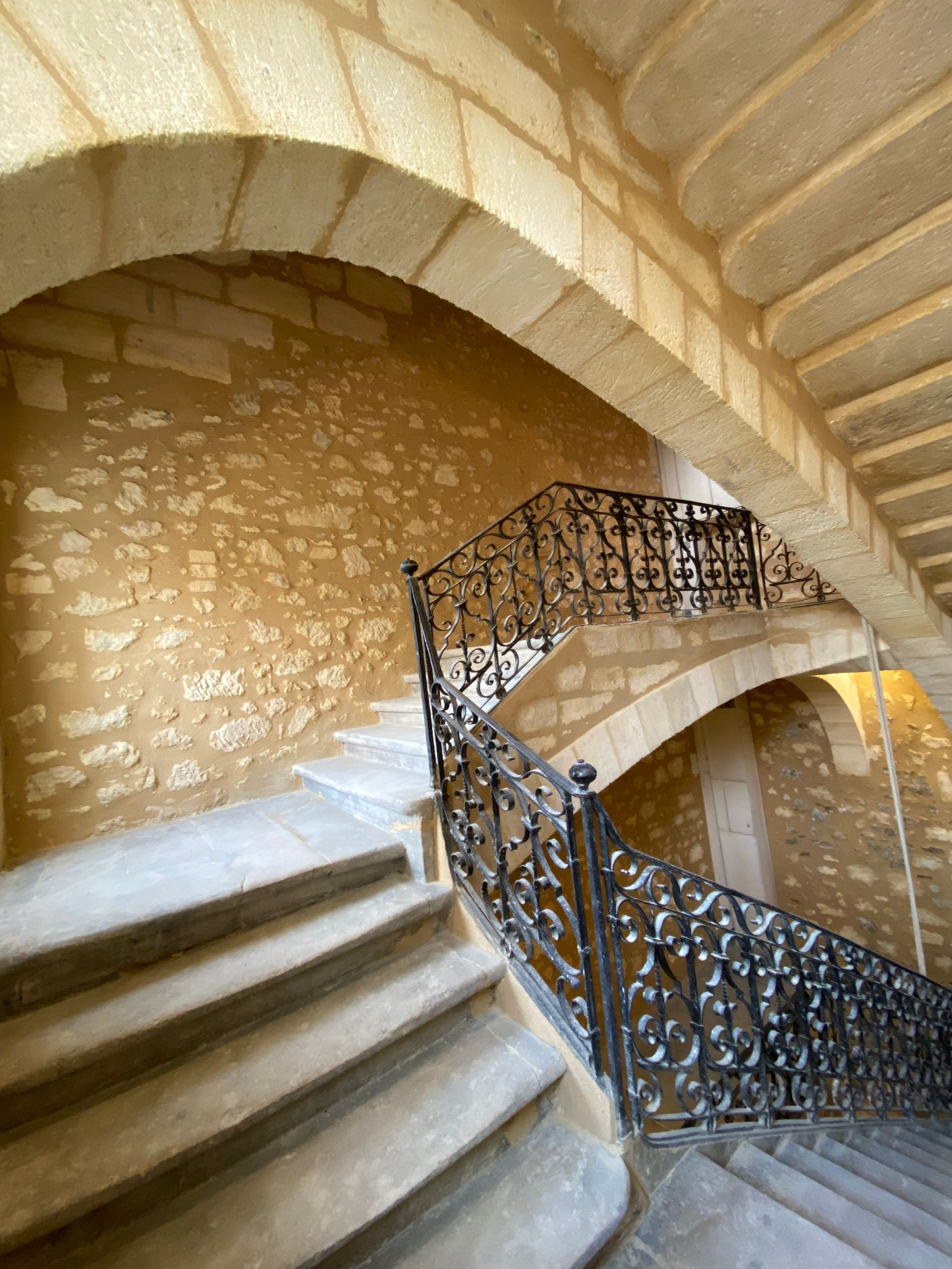 Un escalier intérieur entouré de murs en pierre