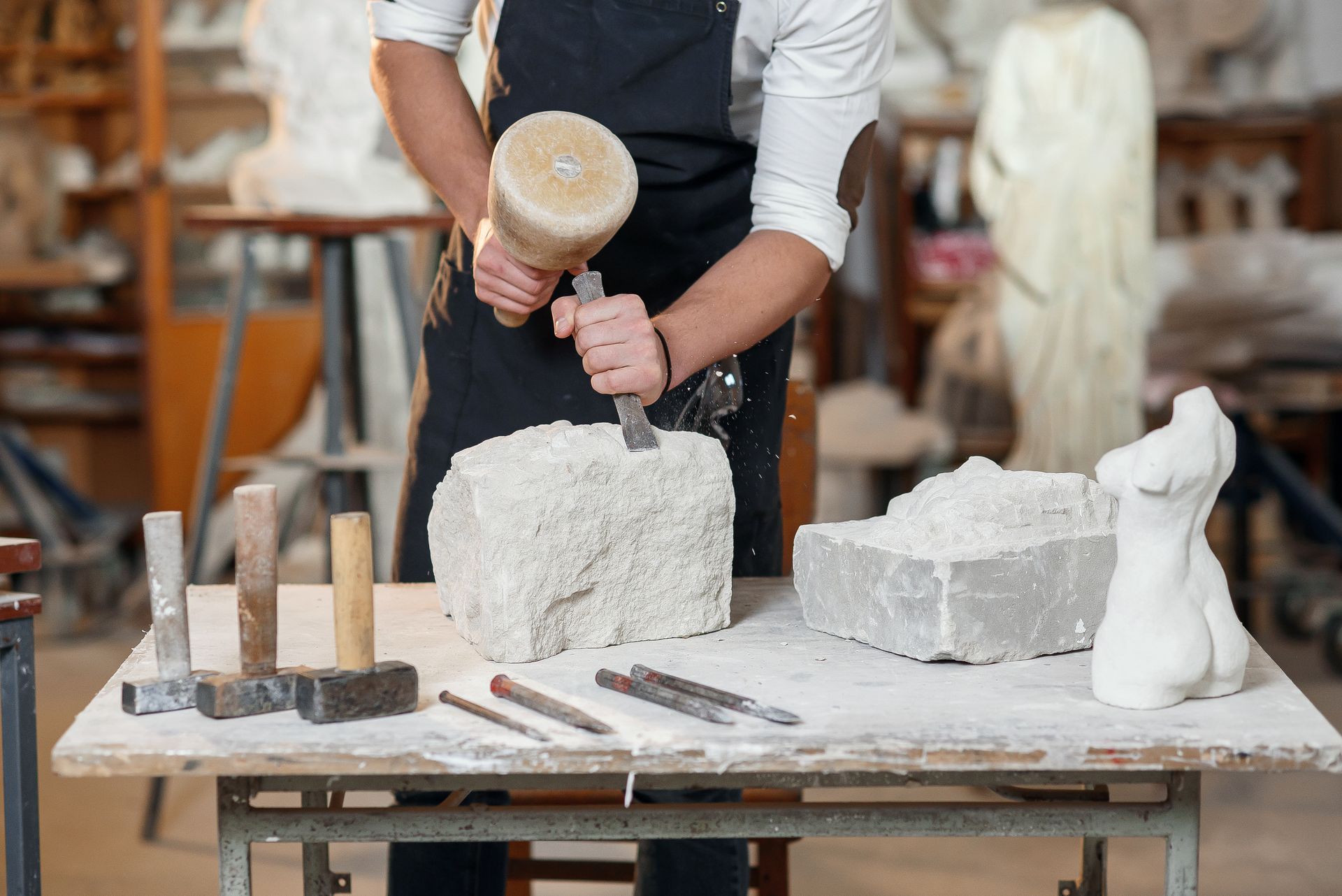 Artisan taillant un bloc de pierre