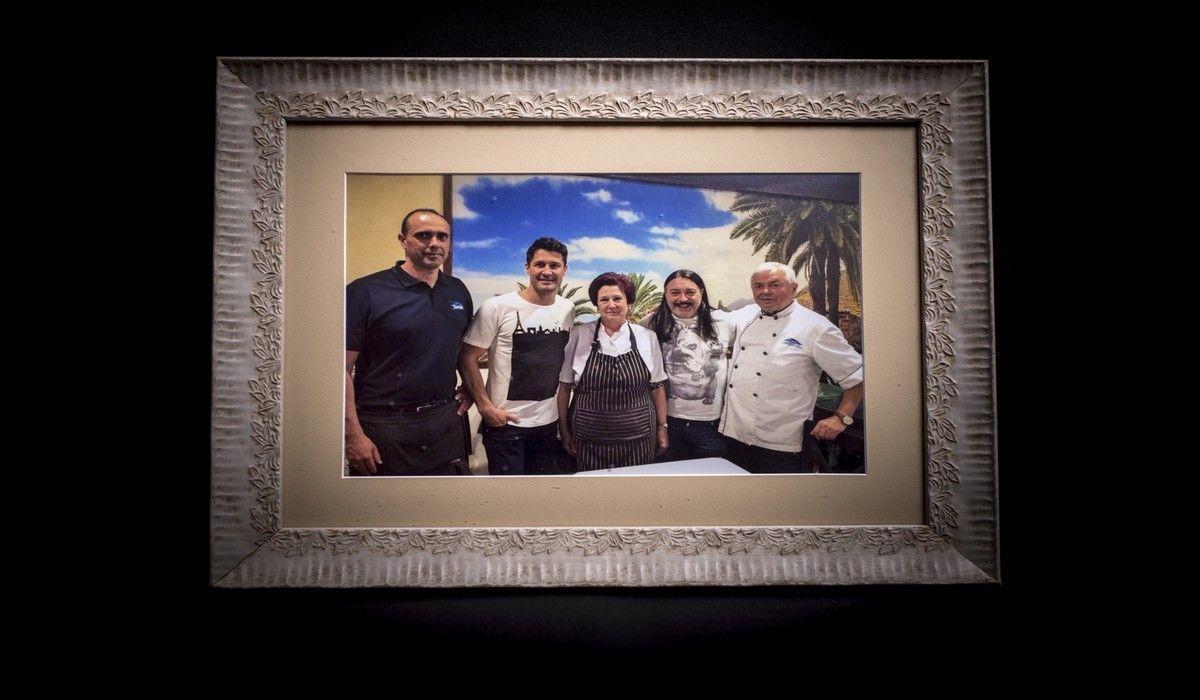 Una fotografía enmarcada de una familia de pie uno al lado del otro.