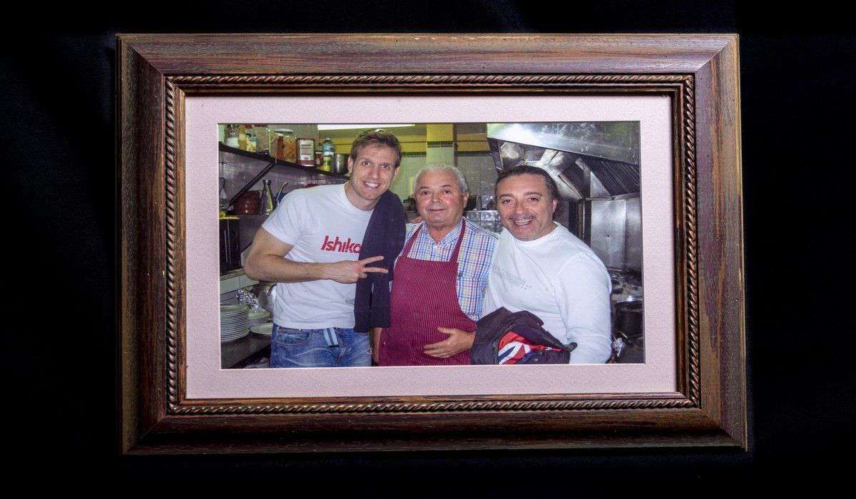 Una fotografía enmarcada de tres hombres en una cocina.