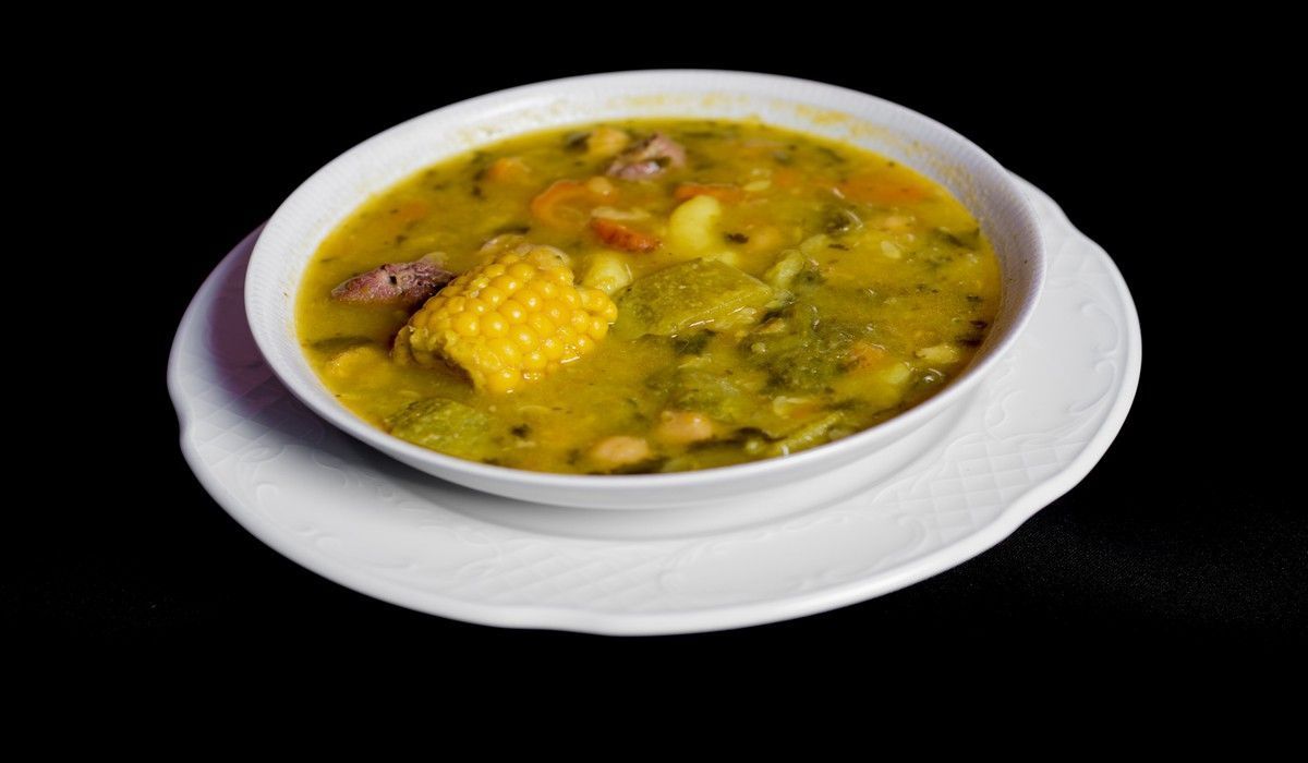 Un tazón de sopa con maíz y frijoles en un plato blanco