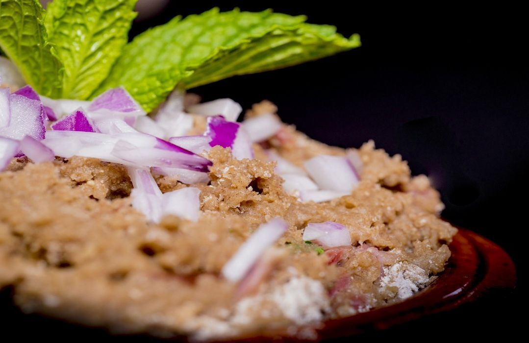 Un primer plano de un plato de comida con cebollas y una hoja de menta encima.