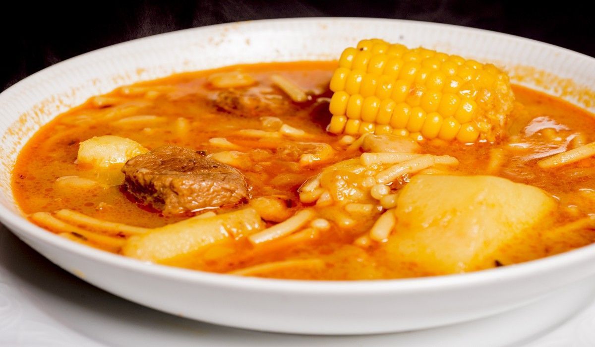 Hay un tazón de sopa con mazorcas de maíz dentro.
