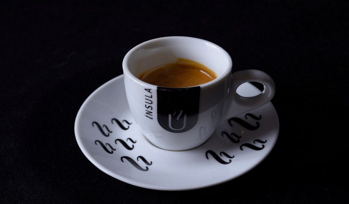 Una taza de café en un platillo que dice 'cápsula'.