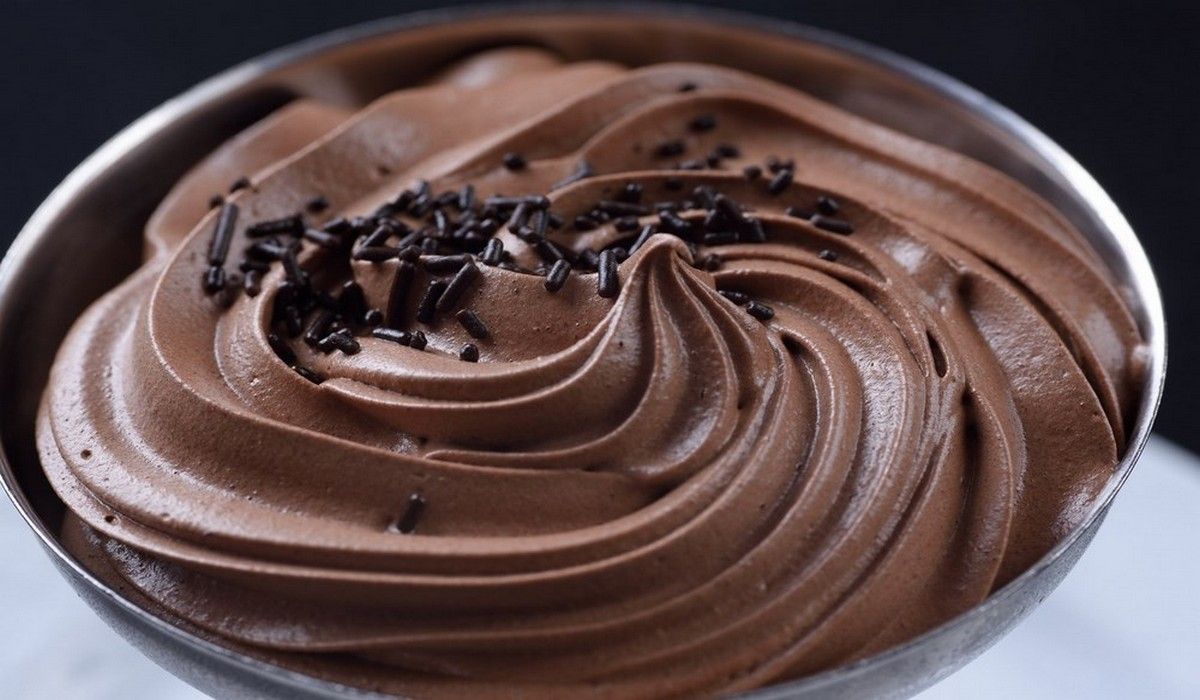 Un tazón de glaseado de chocolate con chispas de chocolate encima