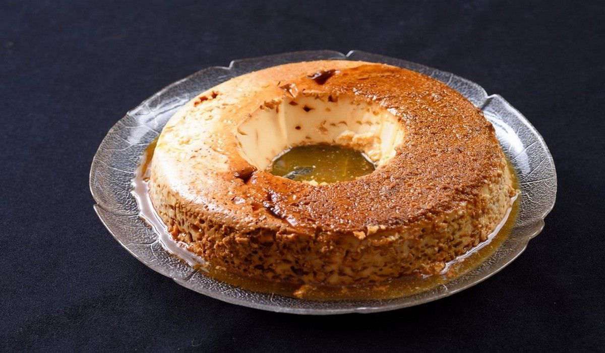 Un primer plano de un pastel en un plato de vidrio sobre una mesa.