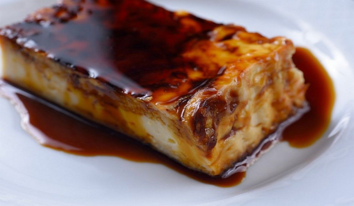 Un trozo de pastel en un plato con salsa encima.