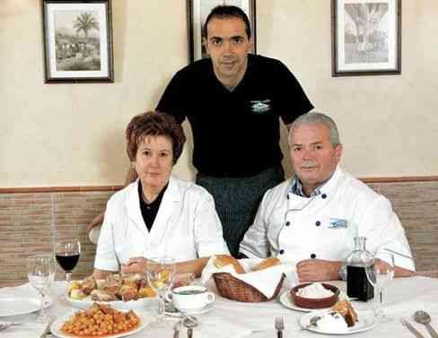 Un grupo de personas está sentada en una mesa con comida.
