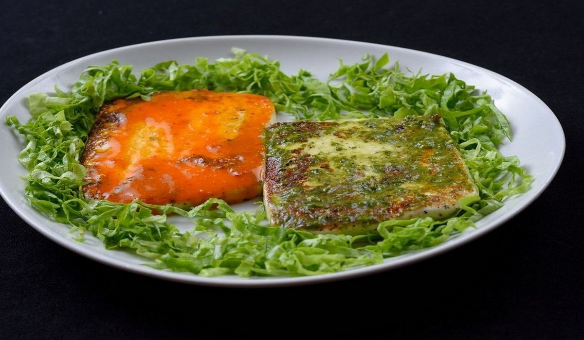 Un plato de comida con lechuga y tomates en una mesa.
