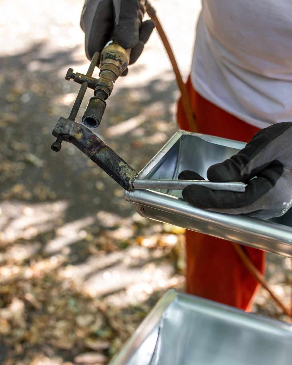 Cheminée sur un toit de tuiles en terre cuite avec solins métalliques pour l'étanchéité.