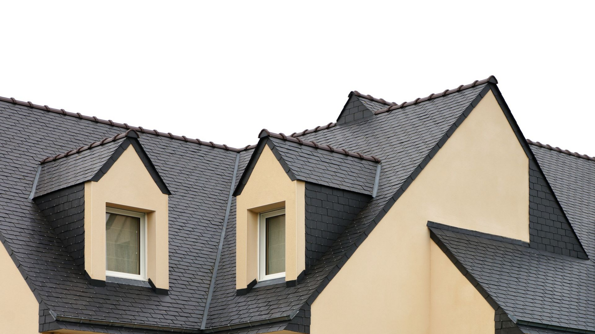 Maison blanche au toit noir, cheminée et fenêtres à encadrement sombre se détachant sur un ciel bleu.