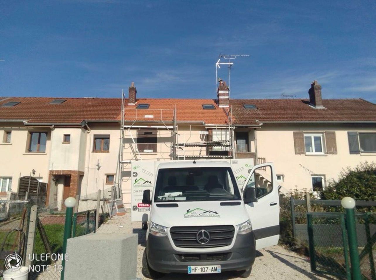 Photo de travaux de couverture avec camion floqué au nom de l'entreprise Lasnon Couverture