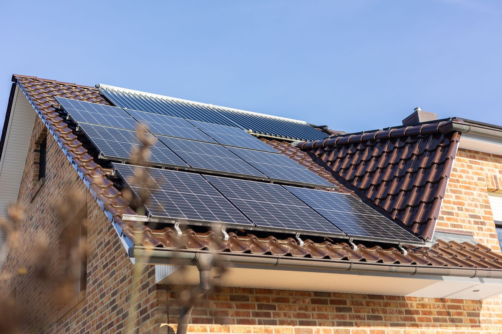 Ein Backsteinhaus mit Solarzellen auf dem Dach.