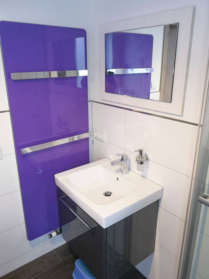 Ein Badezimmer mit einer lila Wand und einem Waschbecken